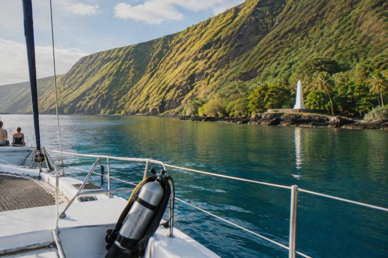 A catamaran moored in Kealakekua Bay below the cliffs near the Captain Cook monument